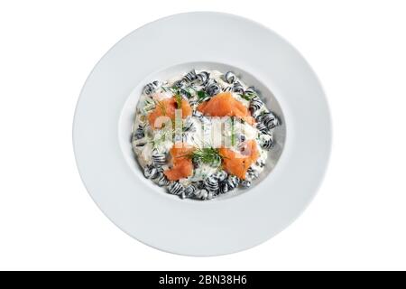 Pasta with salmon stewed in greens and sauce. On white background. Stock Photo