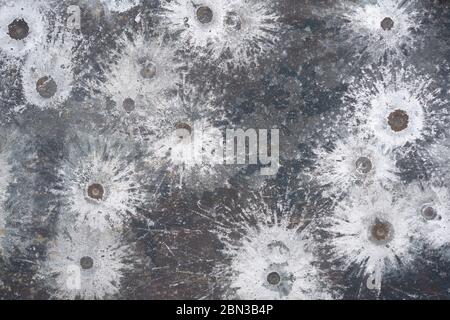 white splatters of lead spalling from a 45 pistol on a target Stock Photo