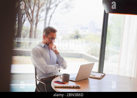 Businessman using laptop, working from home Stock Photo