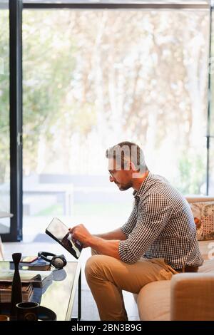 Businessman using digital tablet, working from home on sofa Stock Photo