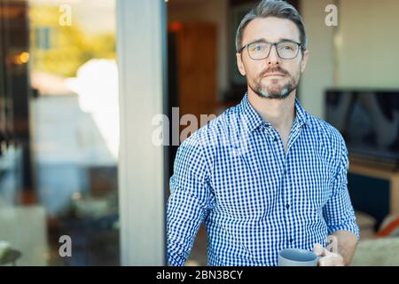 Portrait confident businessman drinking coffee in doorway Stock Photo