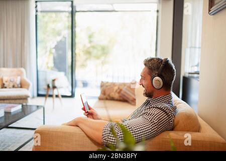 Man with headphones and mp3 player listening to music at home Stock Photo