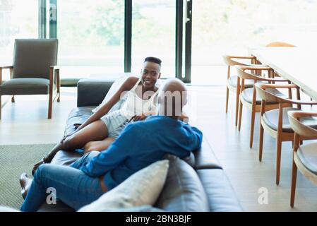 Father and daughter talking on living room sofa Stock Photo