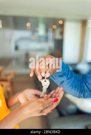 Close up man handing house keys to woman Stock Photo