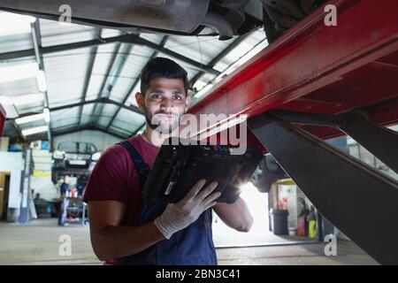 Portrait confident male mechanic with diagnostic equipment in auto repair shop Stock Photo