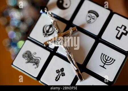 Crucifix on a Rubik's cube with religious symbols. Interreligious and interfaith dialog concept. Stock Photo