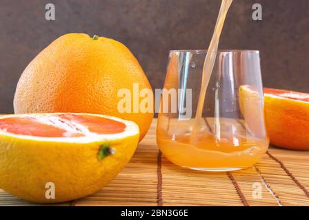 grapefruit juice and fresh grapefruit. Citrus vitamin juice in a clear glass with fruit. Stock Photo
