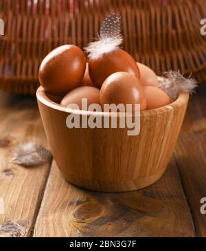 rustic eggs, from homemade chickens, on a wooden background, with feathers. Eco foods, clean food. Vintage photo. The concept of natural food. Copy space. Stock Photo
