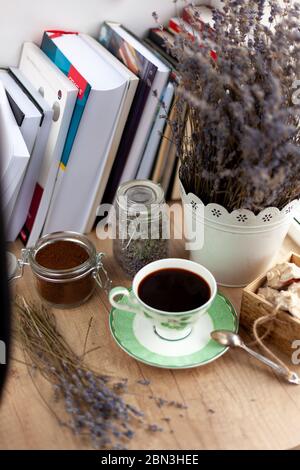 Books, coffee and a bouquet of dried lavender. Still life on the table. Breakfast top view. A cup of invigorating drink. Home cozy background. Stock Photo