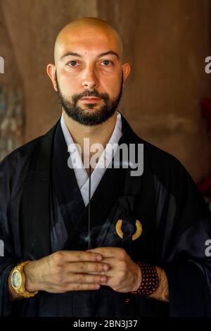 Buddhist monk holding an incense stick Stock Photo - Alamy