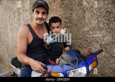 Father and son sitting on a scooter in Casablanca, Morocco. Stock Photo
