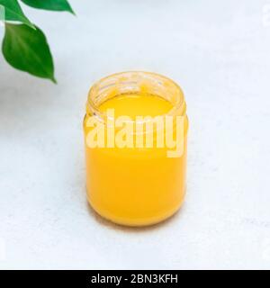 Gut-healthy, energy boosting jar of ghee butter on neutral background, copy space