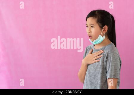 Asia little girl wearing hygienic mask to prevent the virus, PM2.5, Coronavirus, (2019-nCoV). Asian little girl feeling unwell and coughing isolated o Stock Photo