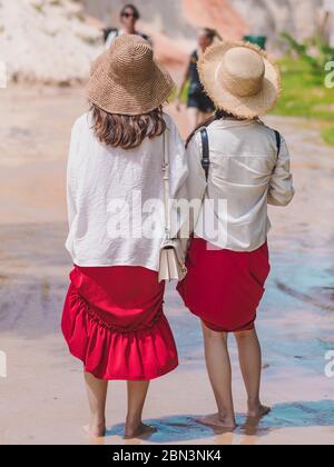 Back view of tourists walk on feet in the Red Stream ( it also named Fairy Stream) with Beautiful scenic landscape with red river, sand dunes and jung Stock Photo