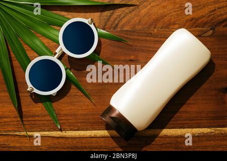Different items for beach vacations. Sunscreen, sunglasses on wooden surface Stock Photo