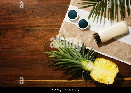 Different items for beach vacations. Sunscreen, sunglasses and pineapple fruit Stock Photo