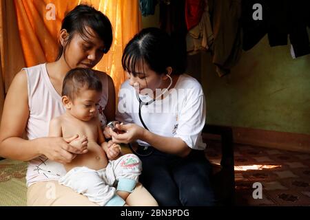 Volunteer of French NGO Chaine de l'Espoir visiting a child suffering of heart disease. Medical consultation. Buon Me Thuot. Vietnam. Stock Photo