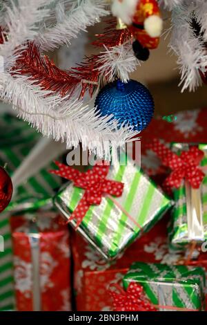 Presents under the decorated artificial Christmas tree. Stock Photo