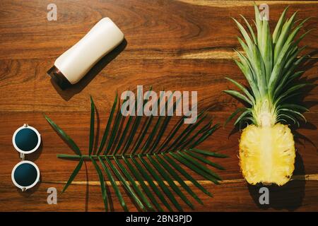 Different items for beach vacations. Sunscreen, sunglasses and pineapple fruit Stock Photo