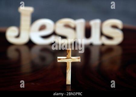 Wooden letters forming the word JESUS and cross.  Christian symbol. Stock Photo