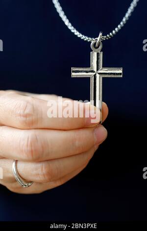 Dominican nun holding her christian cross. Close-up on hand.  Vietnam. Stock Photo