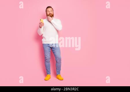 Full length body size view of his he nice attractive creative curious cheerful cheery red guy holding in hands device creating comment feedback Stock Photo
