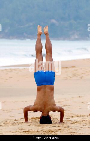 Man doing morning gymnastic on the beach.  Quy Nhon. Vietnam. Stock Photo