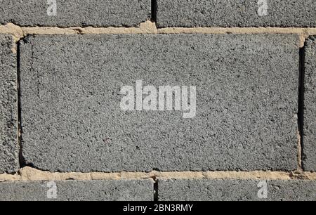 Grey brick, texture and background. Surface and blank for inscription. Mock-up. Slag (cinder) block or expanded brickwork. Slag bricks in building Stock Photo