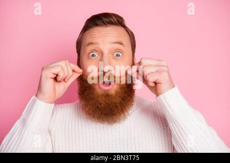 Close-up portrait of his he nice attractive funny playful childish comic cheerful cheery humorous red guy touching mustache fooling isolated over pink Stock Photo