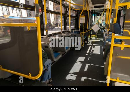 An M20 bus in New York showing the barricade protecting the operator on Saturday May 2, 2020. Since the lockdown bus ridership has declined 80% and subway ridership dropped 90%. (© Richard B. Levine) Stock Photo