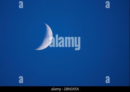 partial moon during the day, blue sky Stock Photo