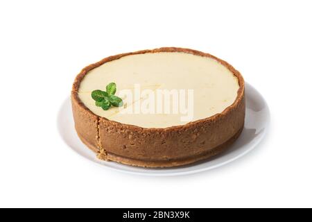 Plane round classic New York cheesecake with sprig of mint on a plate isolated on white background