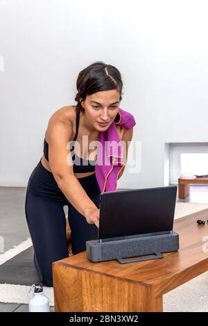 Woman sweaty after practicing an online yoga session at home Stock Photo