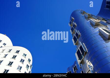 Low angle view of two buildings designed by the American star architect Frank O. Gehry at 'Neuer Zollhof' in the Media Harbour (Medienhafen) district. Stock Photo