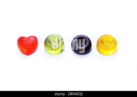 Multicolored round and heart shaped lollipops lying on a white background Stock Photo