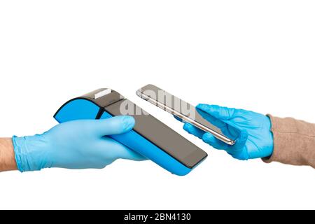 Customer in gloves is paying with smartphone to deliver on contactless terminal in hands of courier. Stock Photo