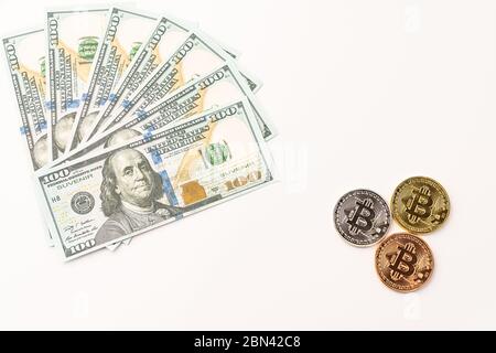 Gold Bit Coin BTC coins and bills of 100 dollars. Worldwide virtual internet cryptocurrency and digital payment system. Stock Photo