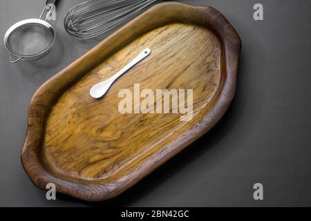 The wooden tray contains white ceramic spoon Stock Photo