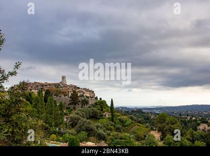 The town of Saint-Paul-de-Vence looks out over the surrounding French landscape, with low clouds and green hills Stock Photo