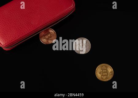 Red wallet and physical bitcoin coins isolated on black background Stock Photo