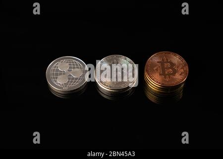 Silver and gold bitcoin coins and silver ripple coin isolated on black Stock Photo