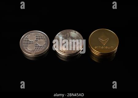Close up photo of physical coins of ripple, ethereum and bitcoin isolated on black Stock Photo