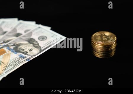 US dollar banknotes and bitcoin golden coin isolated on black background Stock Photo