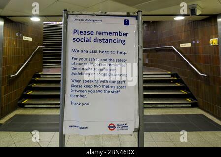 London, UK.  12 May 2020. At Bond Street tube station, an instruction to passengers to maintain social distancing. Off peak on the London Underground.   As some restrictions imposed during the coronavirus pandemic lockdown are relaxed, the UK government is encouraging people to return to work and, if they must take public transport, to travel off peak, wear a face covering and practice social distancing when they do so.  Credit: Stephen Chung / Alamy Live News Stock Photo