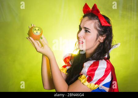 Woman holding hazardous radioactive apple. Nuclear and radiation measurement concept. Stock Photo