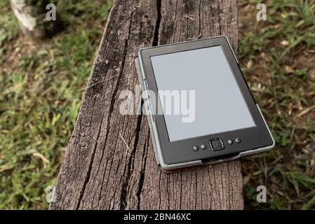 Digital book reader, e-book, on wooden bench in the garden, Areal, Rio de Janeiro, Brazil Stock Photo