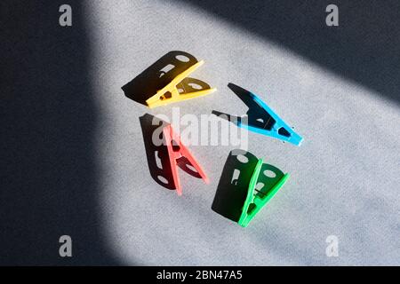 colorful plastic cloth pins on black paper, top view Stock Photo
