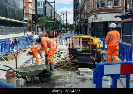 London, UK.  12 May 2020.  Construction workers at a site on Oxford Street.  According to the Office of National Statistics (ONS), male construction workers are among those with the highest coronavirus death rates. Credit: Stephen Chung / Alamy Live News Stock Photo