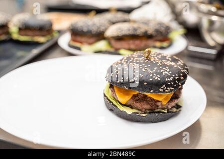 Appetizing black burger on a white plate Stock Photo