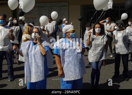 Sao Paulo, Brazil. 12th May 2020. May 12, 2020: About 50 essential health professionals stopped their activities to protest with balloons in front of the University Hospital of Sao Paulo. The protesters, in addition to holding black and white balloons, wore vests with black crosses and walked around the hospital. Credit: Dario Oliveira/ZUMA Wire/Alamy Live News Stock Photo